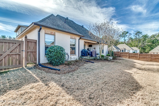 back of house featuring a lawn