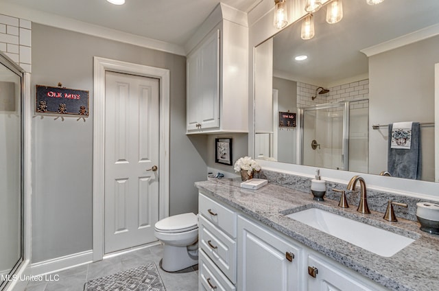 bathroom featuring a shower with shower door, vanity, and crown molding