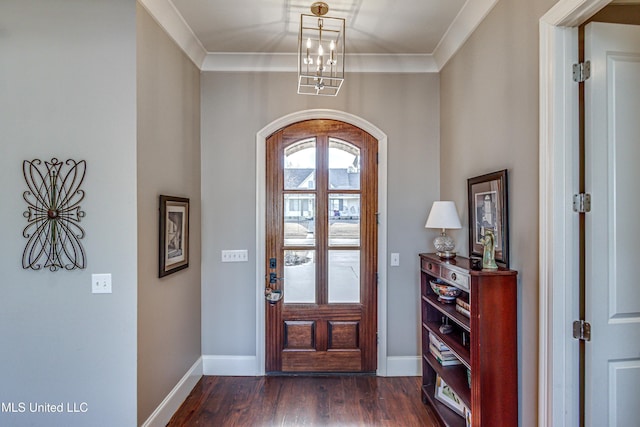 entryway with a chandelier, dark hardwood / wood-style floors, and ornamental molding