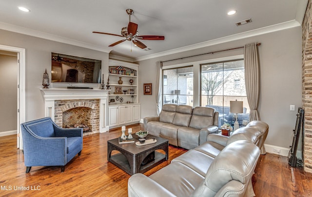 living room with ceiling fan, wood-type flooring, built in features, and ornamental molding