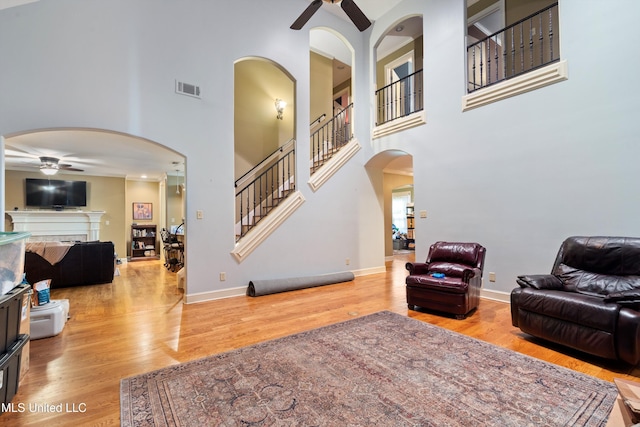 4788 Bon Jour Ln, Nesbit, MS 38651 - living area featuring ceiling fan, arched walkways, stairs, a towering ceiling, and wood finished floors
