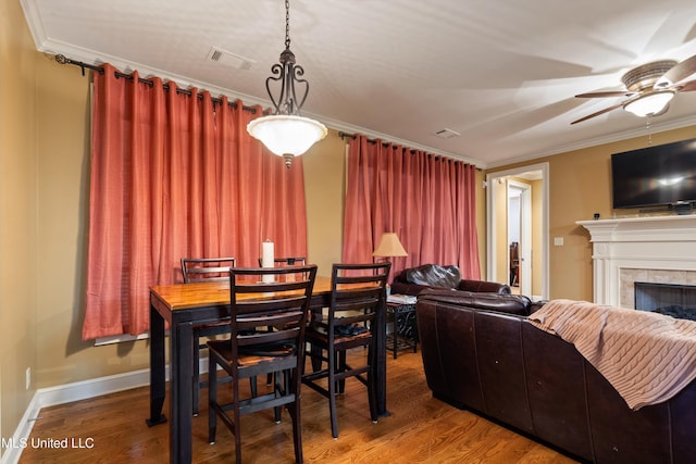 4788 Bon Jour Ln, Nesbit, MS 38651 - dining area featuring crown molding, a ceiling fan, wood finished floors, a fireplace, and baseboards