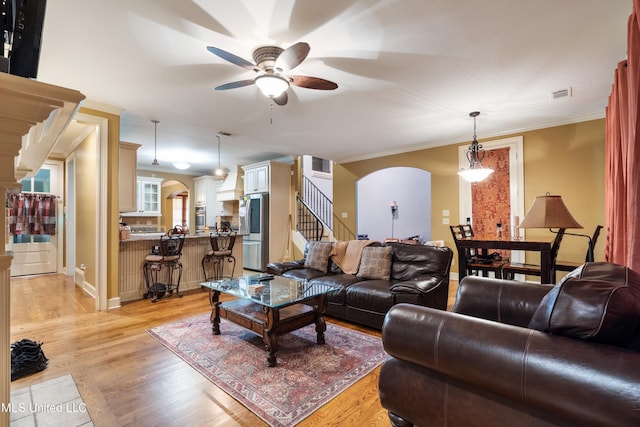 4788 Bon Jour Ln, Nesbit, MS 38651 - living room featuring arched walkways, ceiling fan, light wood-type flooring, ornamental molding, and baseboards