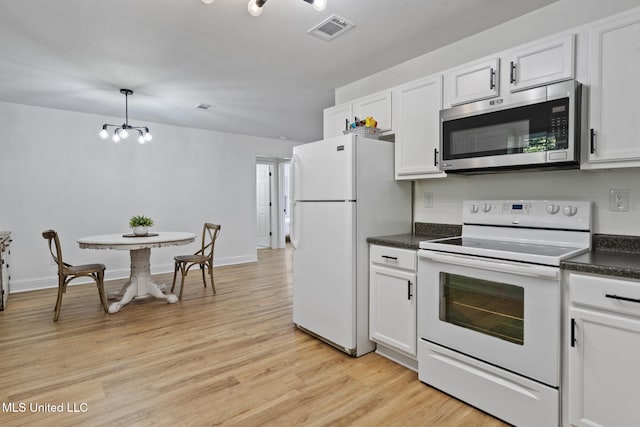 kitchen with light wood finished floors, dark countertops, visible vents, white cabinetry, and white appliances