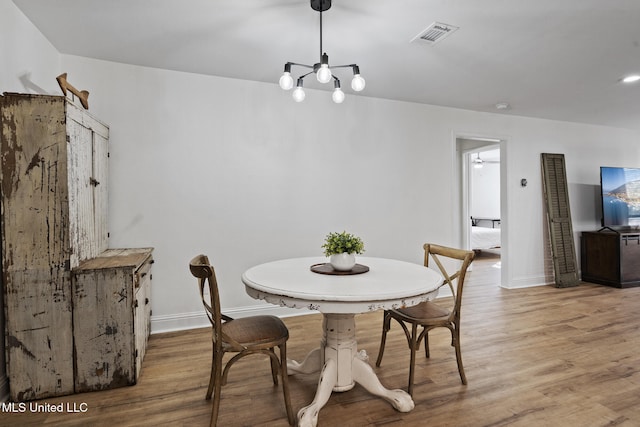 dining room featuring wood finished floors, visible vents, and baseboards