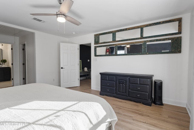 bedroom with visible vents, attic access, a ceiling fan, wood finished floors, and baseboards