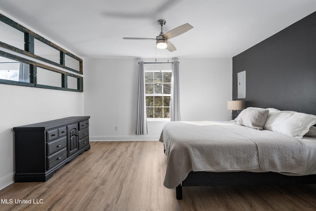 bedroom with light wood-style flooring, baseboards, and a ceiling fan