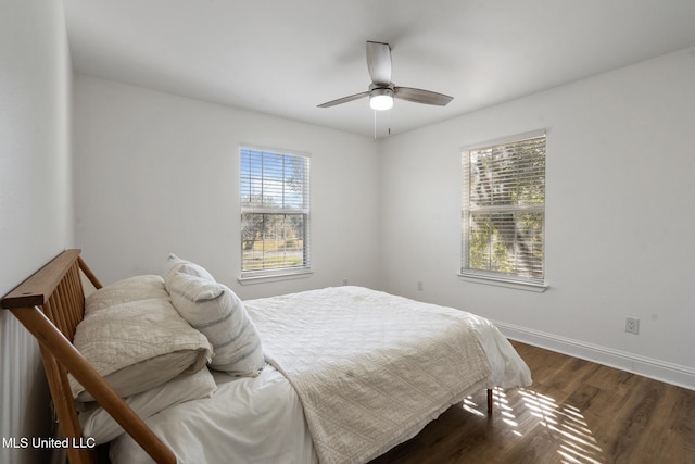 bedroom featuring dark wood-type flooring, baseboards, and a ceiling fan