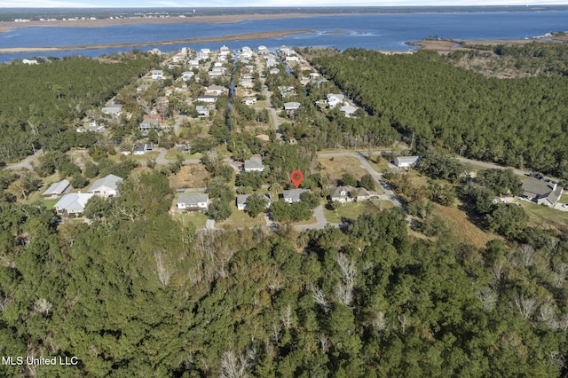 drone / aerial view with a water view and a forest view