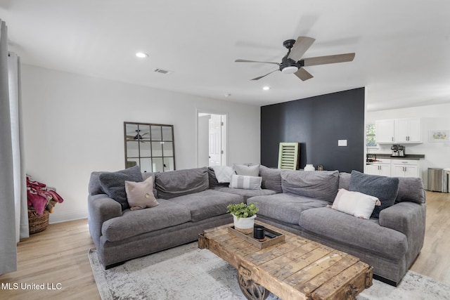 living area with recessed lighting, visible vents, a ceiling fan, light wood-type flooring, and baseboards