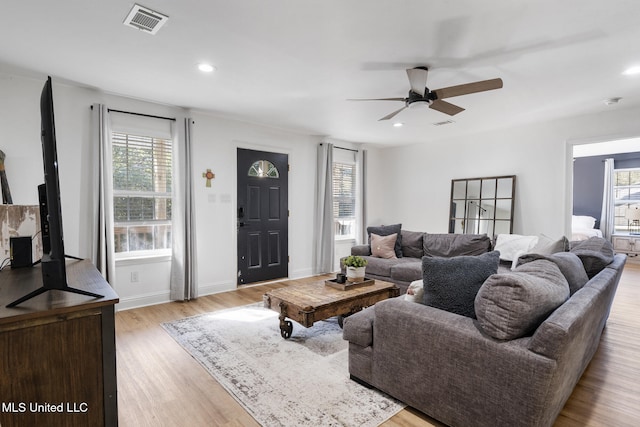 living room featuring light wood-style floors, plenty of natural light, visible vents, and recessed lighting