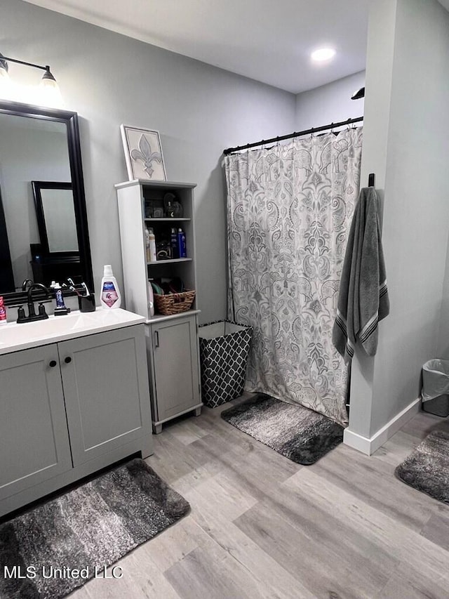 bathroom featuring vanity, curtained shower, and hardwood / wood-style floors