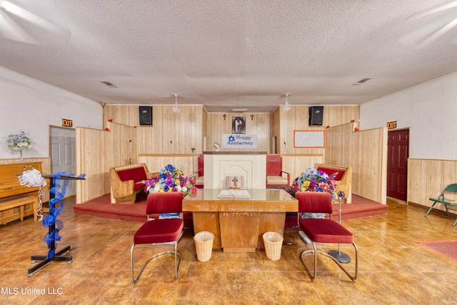 recreation room with a textured ceiling and wood walls