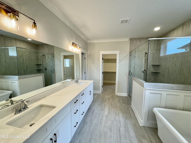 bathroom featuring vanity, ornamental molding, shower with separate bathtub, and wood-type flooring