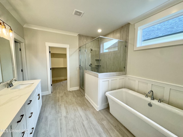 bathroom featuring vanity, crown molding, shower with separate bathtub, and hardwood / wood-style floors