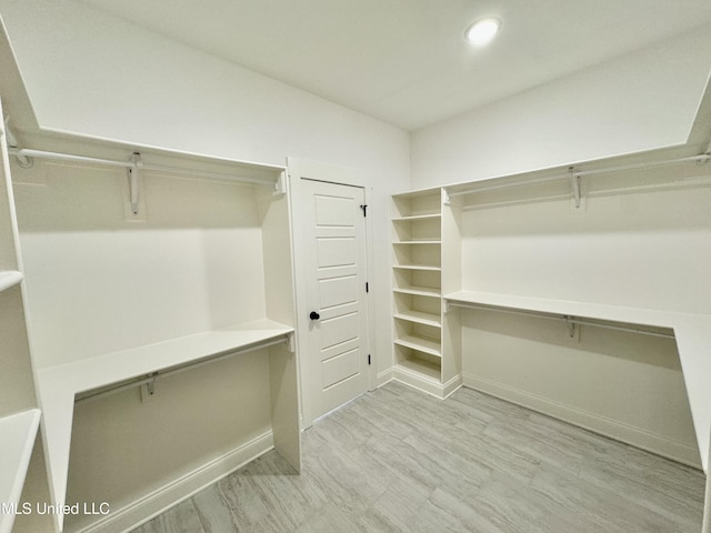 spacious closet featuring light hardwood / wood-style floors