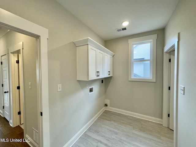 washroom featuring light hardwood / wood-style floors, electric dryer hookup, washer hookup, and cabinets