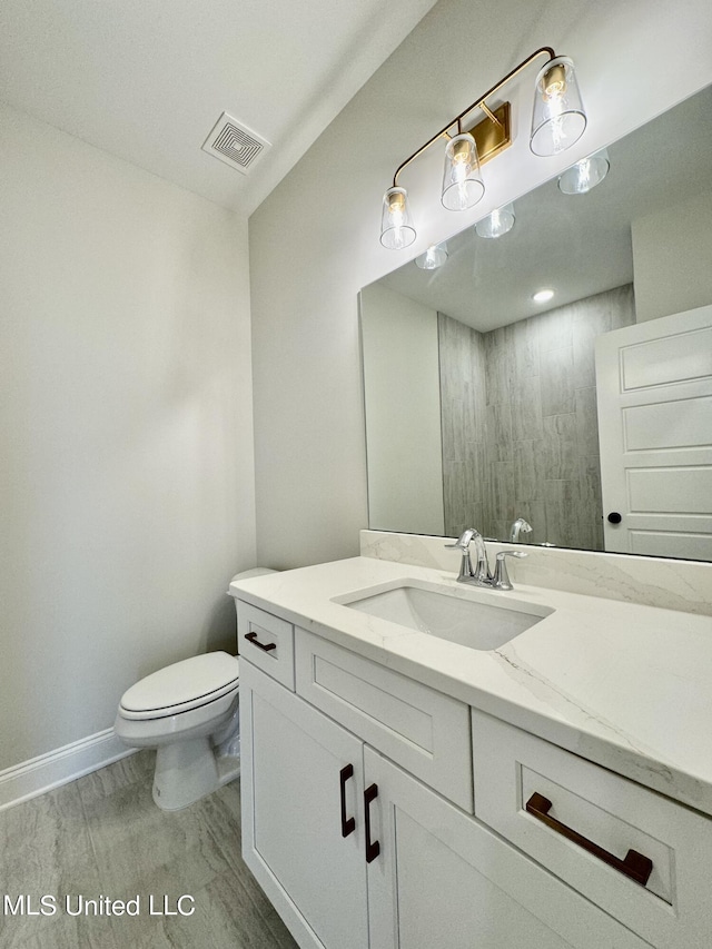 bathroom featuring vanity, toilet, and wood-type flooring