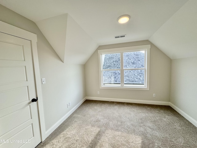 bonus room with carpet flooring and vaulted ceiling