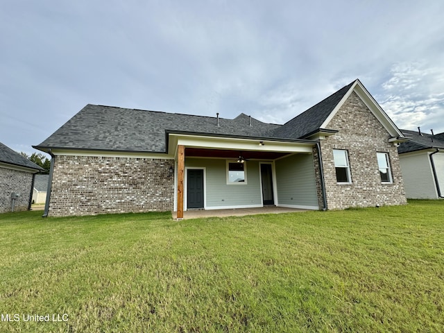 rear view of property with a yard and a patio area