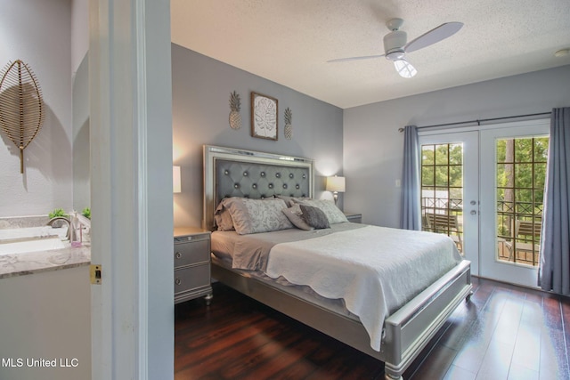 bedroom featuring sink, access to outside, dark wood-type flooring, a textured ceiling, and french doors