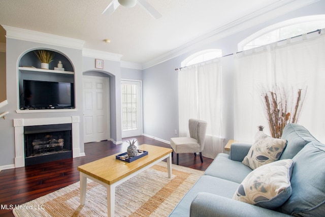 living room with dark hardwood / wood-style floors, built in features, ceiling fan, crown molding, and a textured ceiling