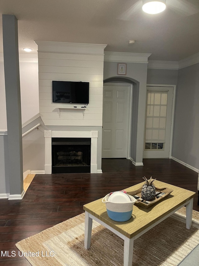 unfurnished living room with ornamental molding and dark hardwood / wood-style flooring