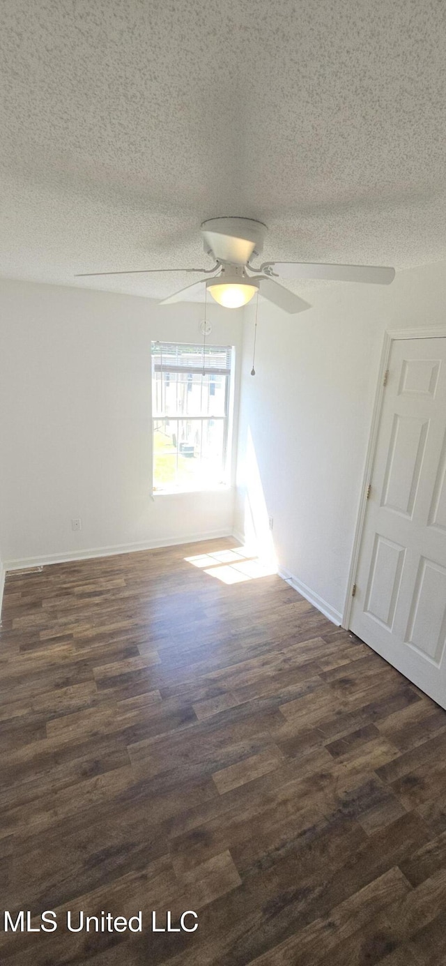 245 Mcdonnell Ave Unit D-226, Biloxi, MS 39531 - unfurnished room with dark wood finished floors, a textured ceiling, a ceiling fan, and baseboards
