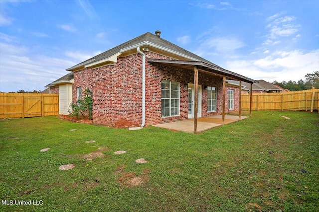 rear view of property with a lawn and a patio area