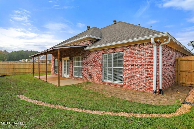 back of house featuring a yard and a patio