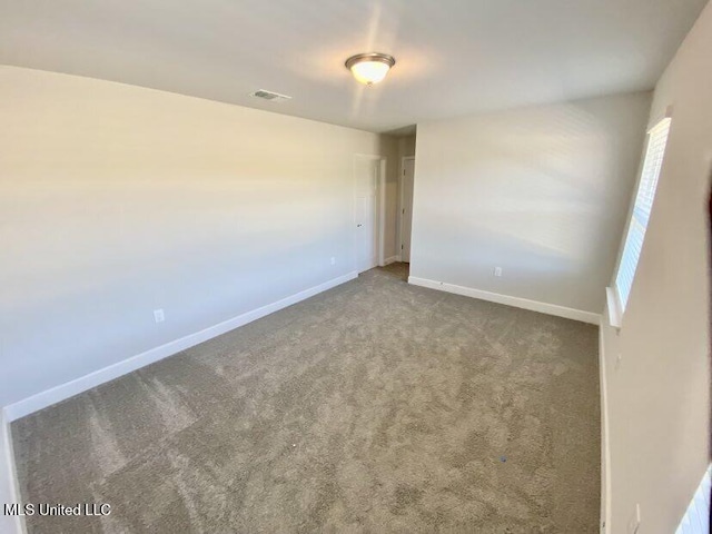 spare room featuring visible vents, baseboards, and carpet floors