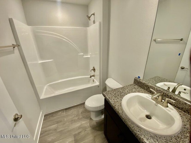 bathroom featuring vanity, toilet, shower / bathing tub combination, and wood finished floors