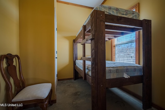 bedroom featuring concrete floors and baseboards