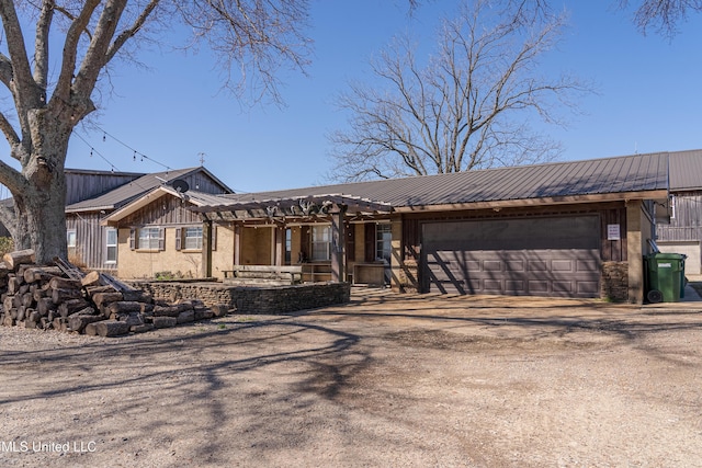 view of front of property featuring a garage, driveway, and metal roof