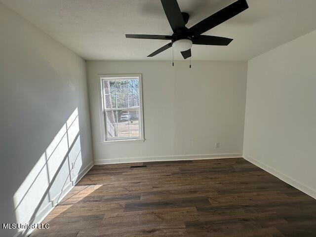 unfurnished room featuring ceiling fan and dark hardwood / wood-style flooring