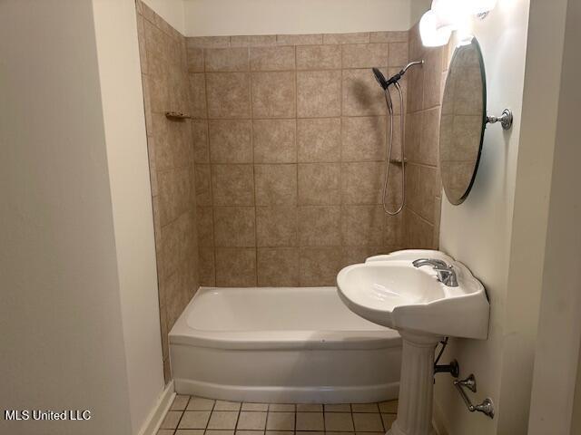 bathroom with tile patterned flooring, sink, and  shower combination