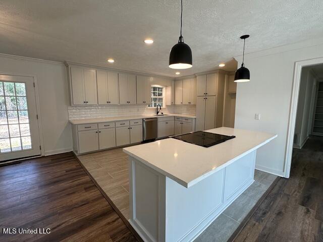 kitchen with hardwood / wood-style floors, pendant lighting, dishwasher, sink, and black electric cooktop