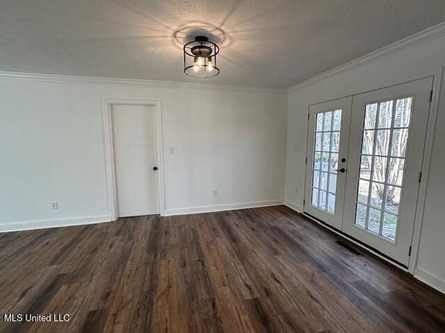 unfurnished dining area with dark hardwood / wood-style flooring, ornamental molding, french doors, and a textured ceiling