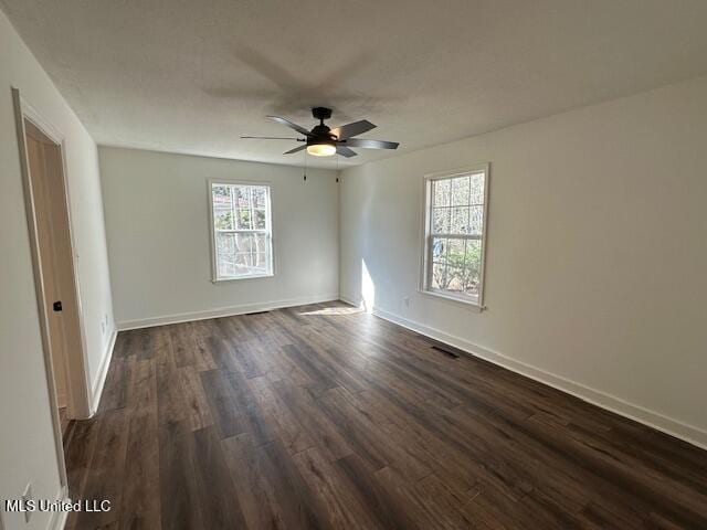 spare room featuring dark wood-type flooring and ceiling fan