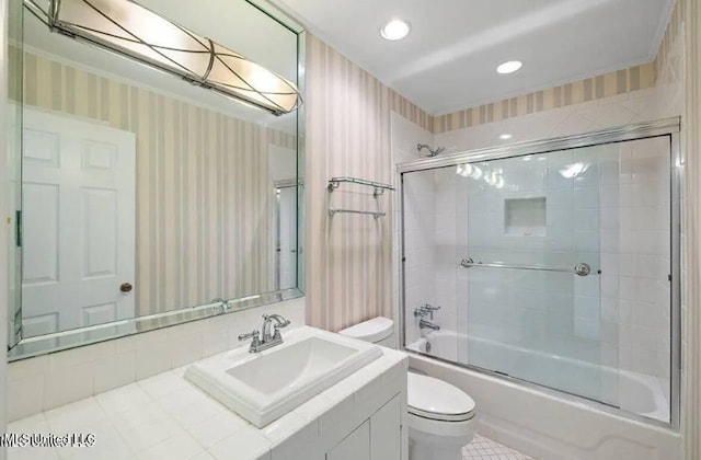 full bathroom with toilet, bath / shower combo with glass door, and vanity