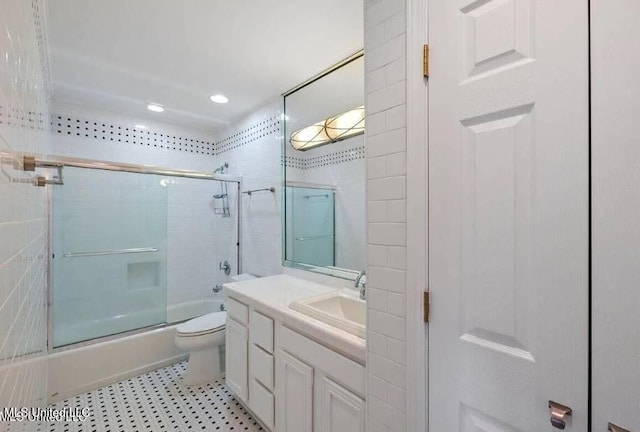 full bathroom with toilet, combined bath / shower with glass door, and vanity