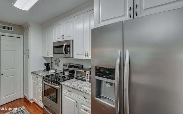 550 Post Rd Unit 116, Ridgeland, MS 39157 - kitchen with stainless steel appliances, white cabinetry, wood finished floors, and light stone countertops