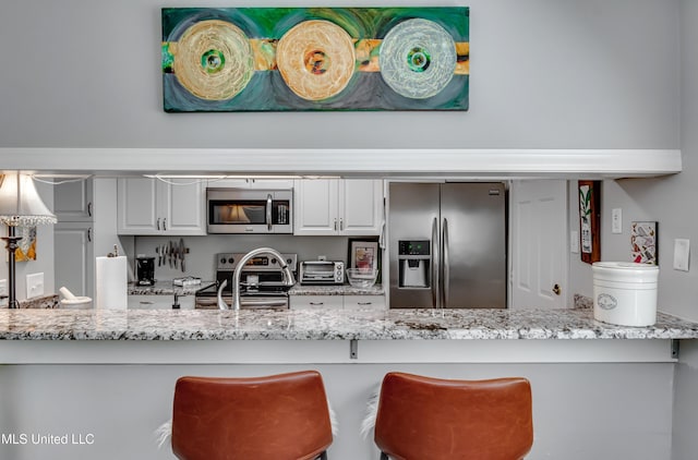 550 Post Rd Unit 116, Ridgeland, MS 39157 - kitchen featuring appliances with stainless steel finishes, light stone counters, and white cabinets
