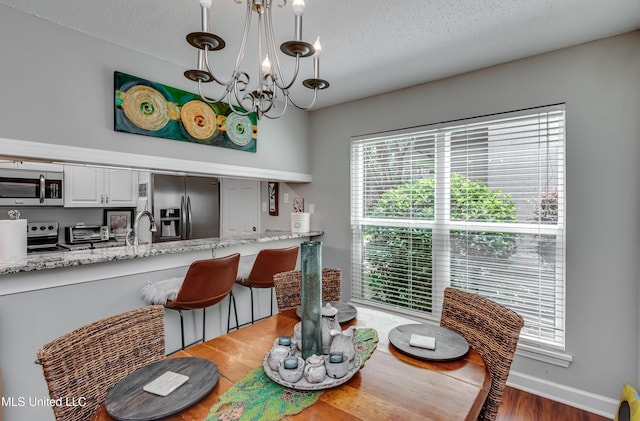 550 Post Rd Unit 116, Ridgeland, MS 39157 - dining area with a chandelier, wood finished floors, and a textured ceiling