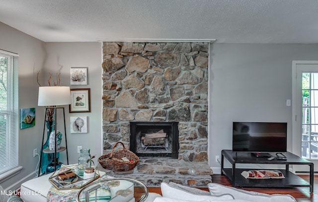 550 Post Rd Unit 116, Ridgeland, MS 39157 - living area featuring a textured ceiling, a stone fireplace, and wood finished floors