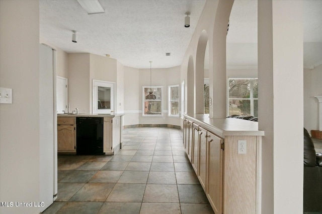 kitchen featuring black dishwasher, light brown cabinetry, a textured ceiling, a center island, and pendant lighting