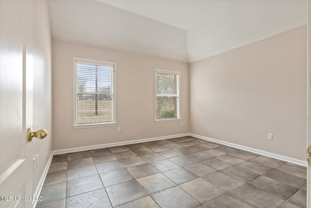 spare room featuring vaulted ceiling and a textured ceiling