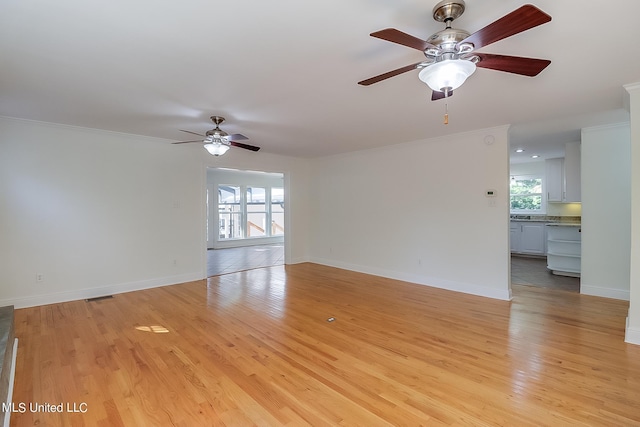 unfurnished room featuring ceiling fan, ornamental molding, and light wood-type flooring