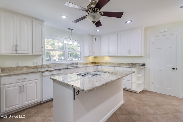 kitchen featuring white dishwasher, decorative light fixtures, and white cabinetry