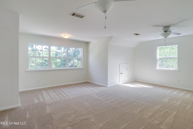 carpeted spare room featuring lofted ceiling, a wealth of natural light, and ceiling fan